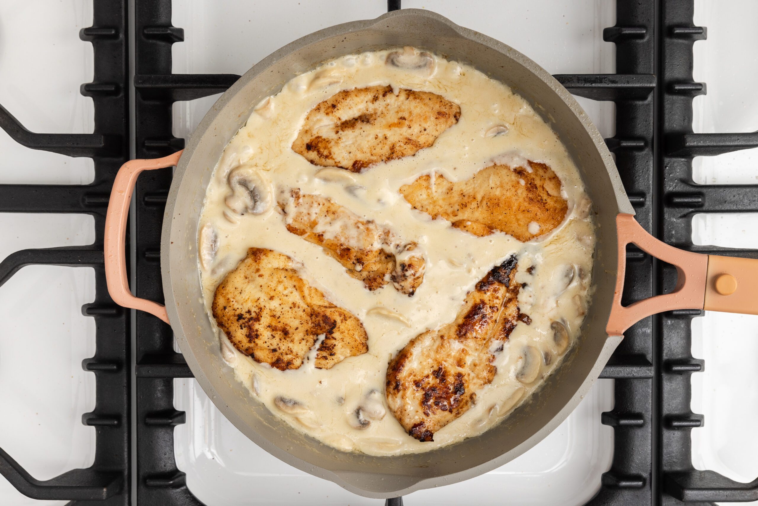 Cooked chicken being mixed with the sauce.