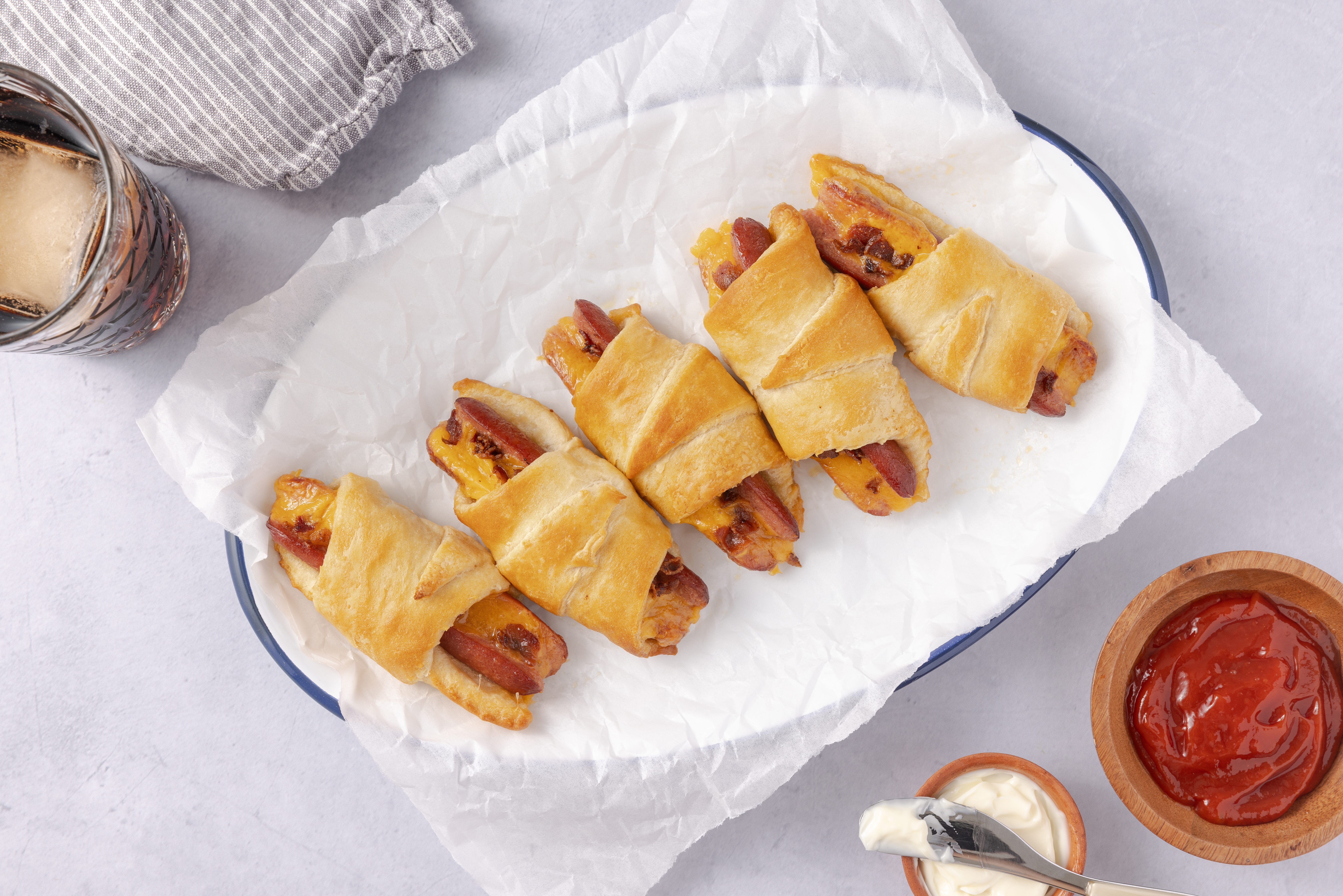 Crescent roll hot dogs baked and served on enamel plate.