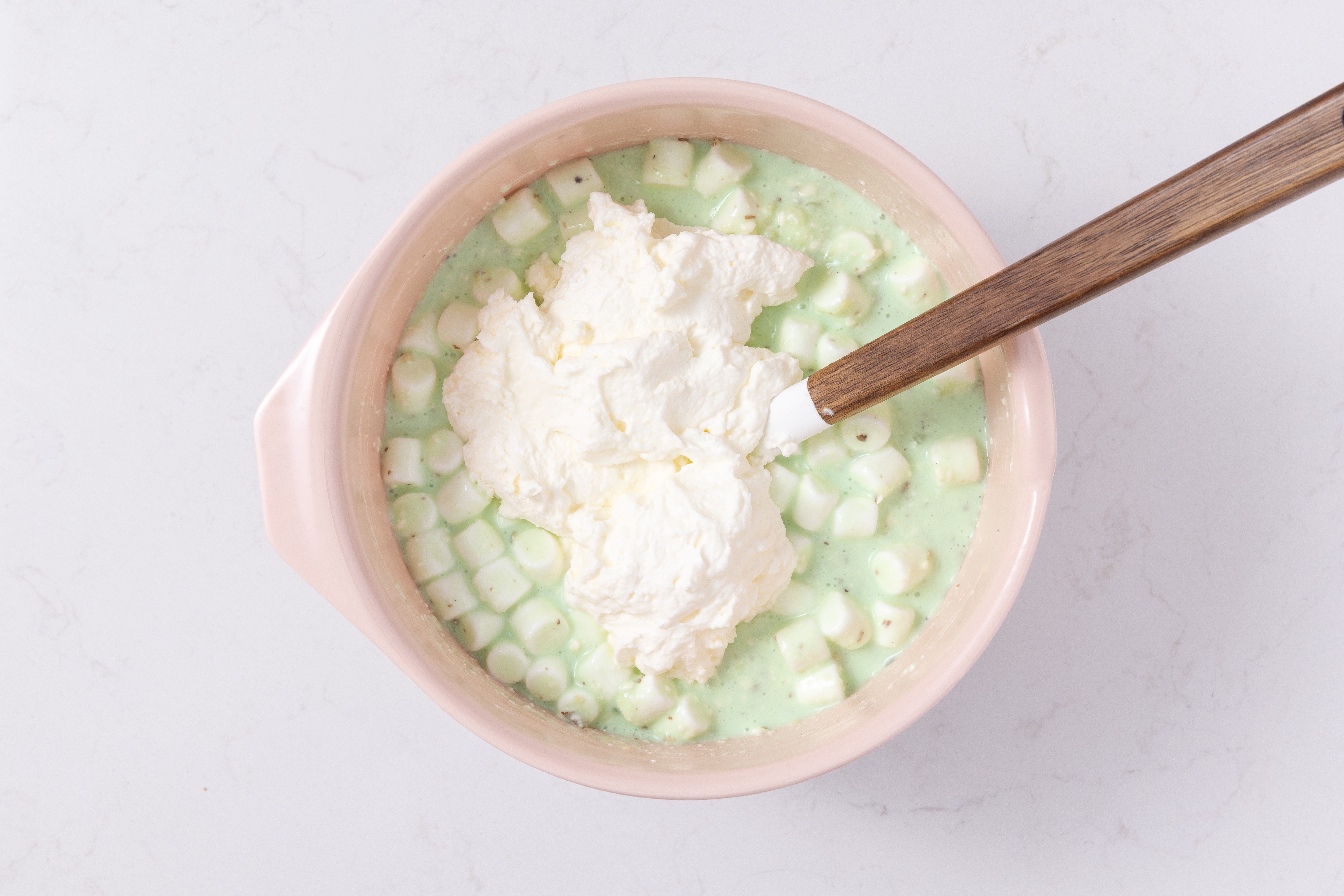 Whipped cream being folded into gelatin mixture.