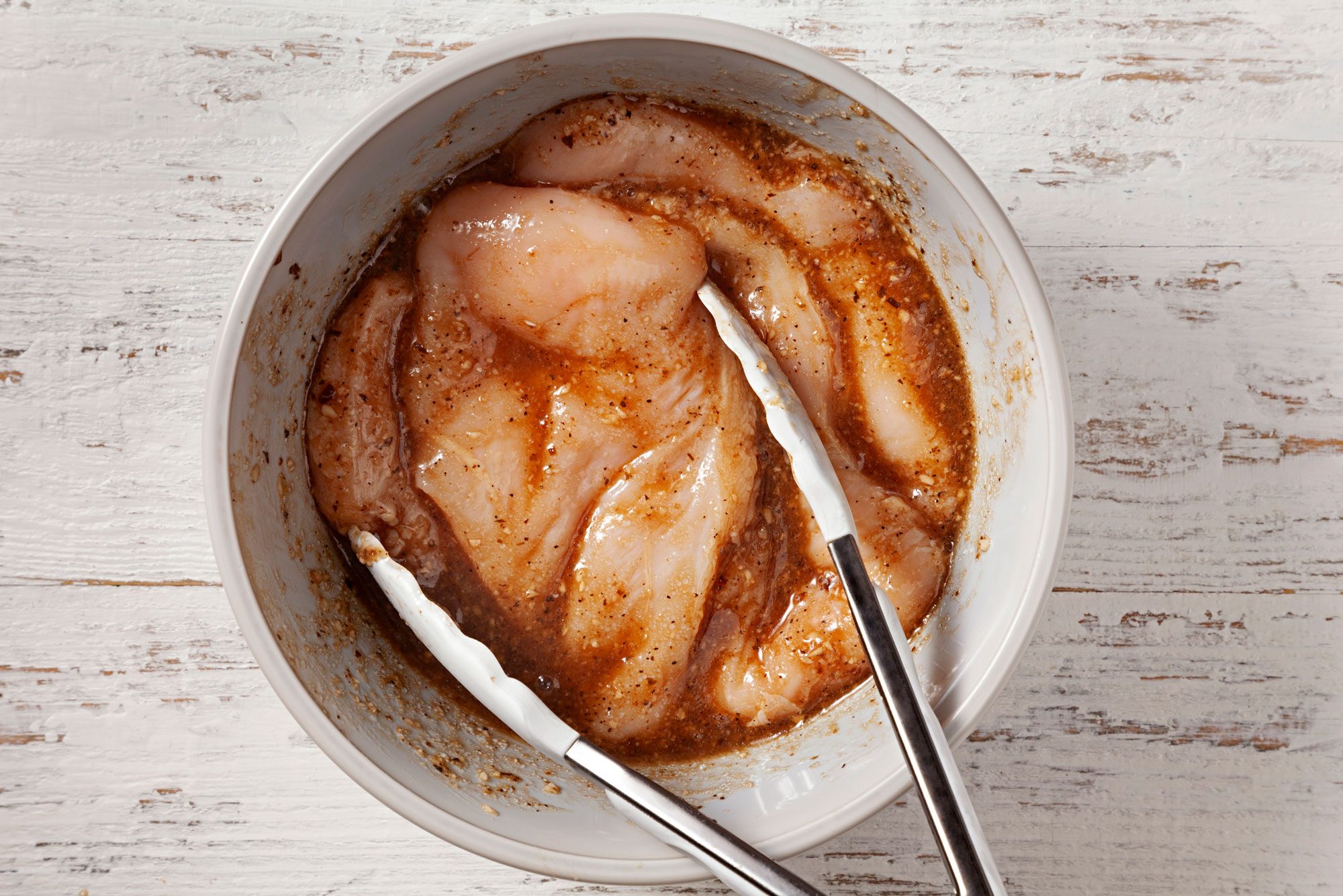 In a large bowl, combine vinaigrette and garlic then add chicken and turn to coat