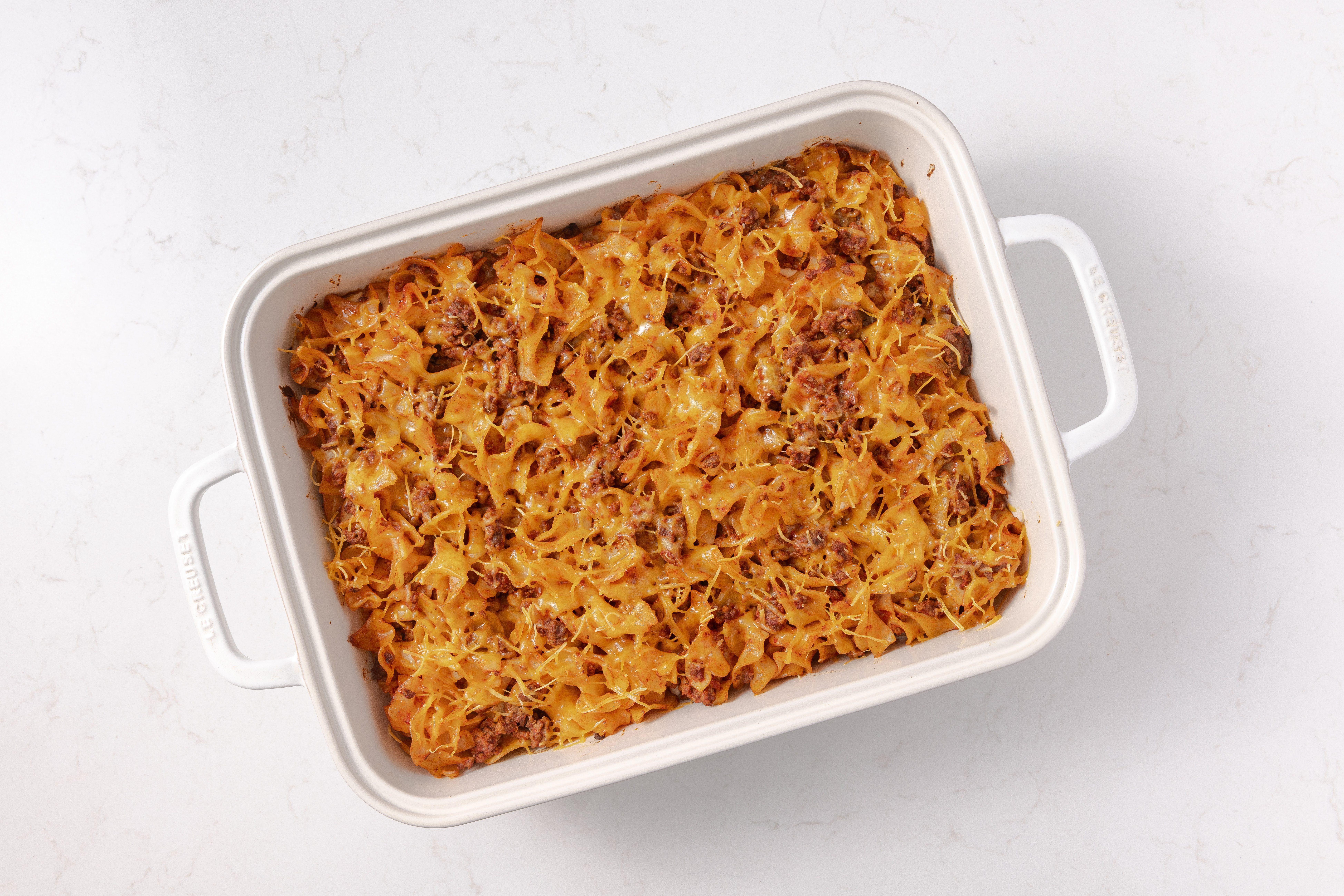 Hamburger noodle casserole assembled and baked in baking dish.