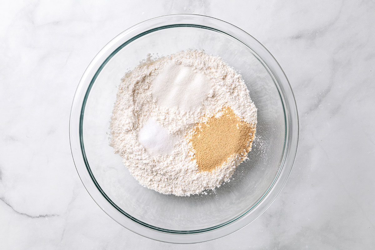 Flour, yeast, sugar and salt in a large mixing bowl for step one of Homemade Breadsticks for Taste of Home