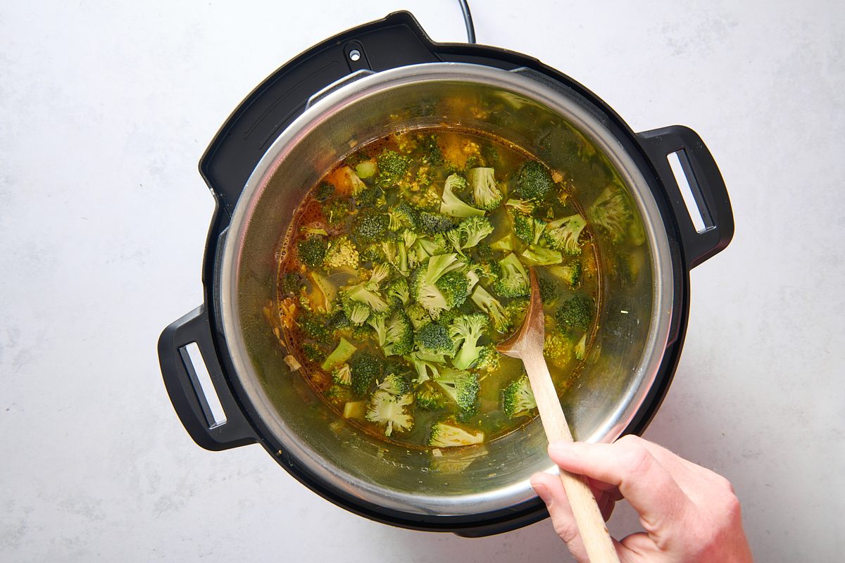 Adding the broth and broccoli to the Instant Pot