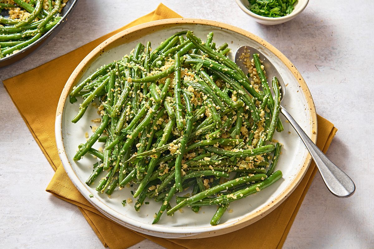 A big plate of Italian green beans with a serving spoon