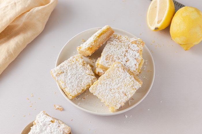 Lemon bars cut into squares and served on plate.