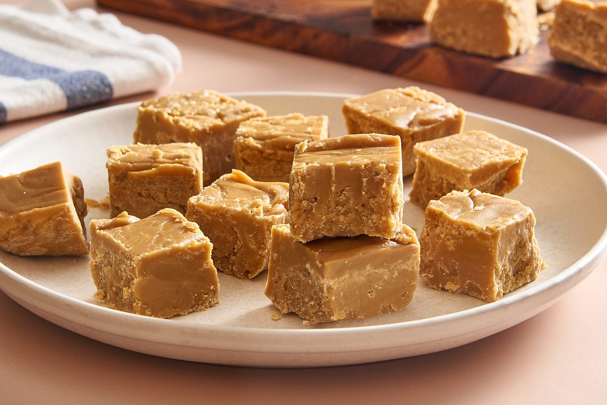 Closeup of pieces of maple fudge on a plate with one stacked on top of another and a bite taken out of it