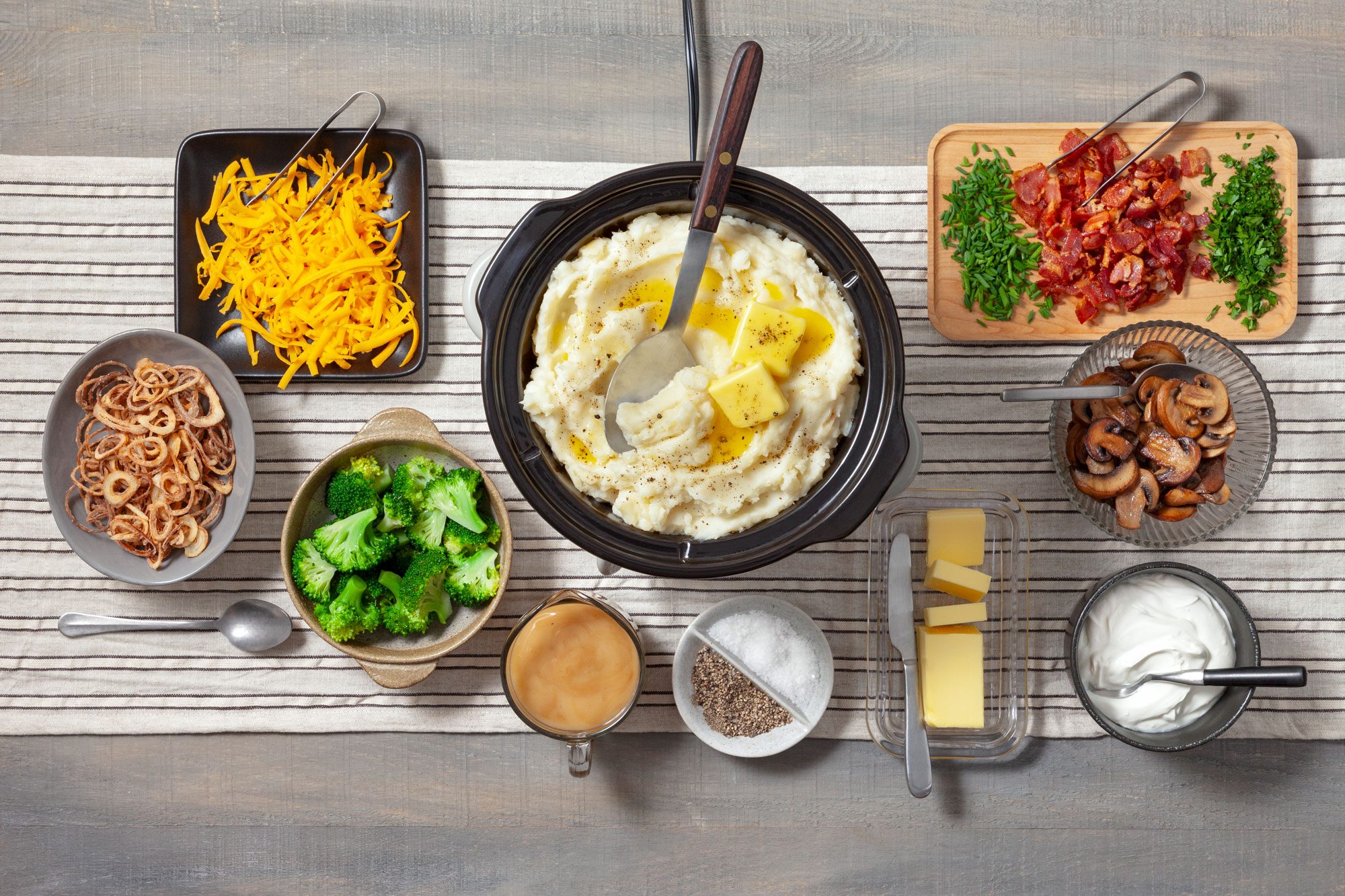 Overhead shot of all ingredients for Mashed Potato Bar; induction; table cloth; wooden surface;