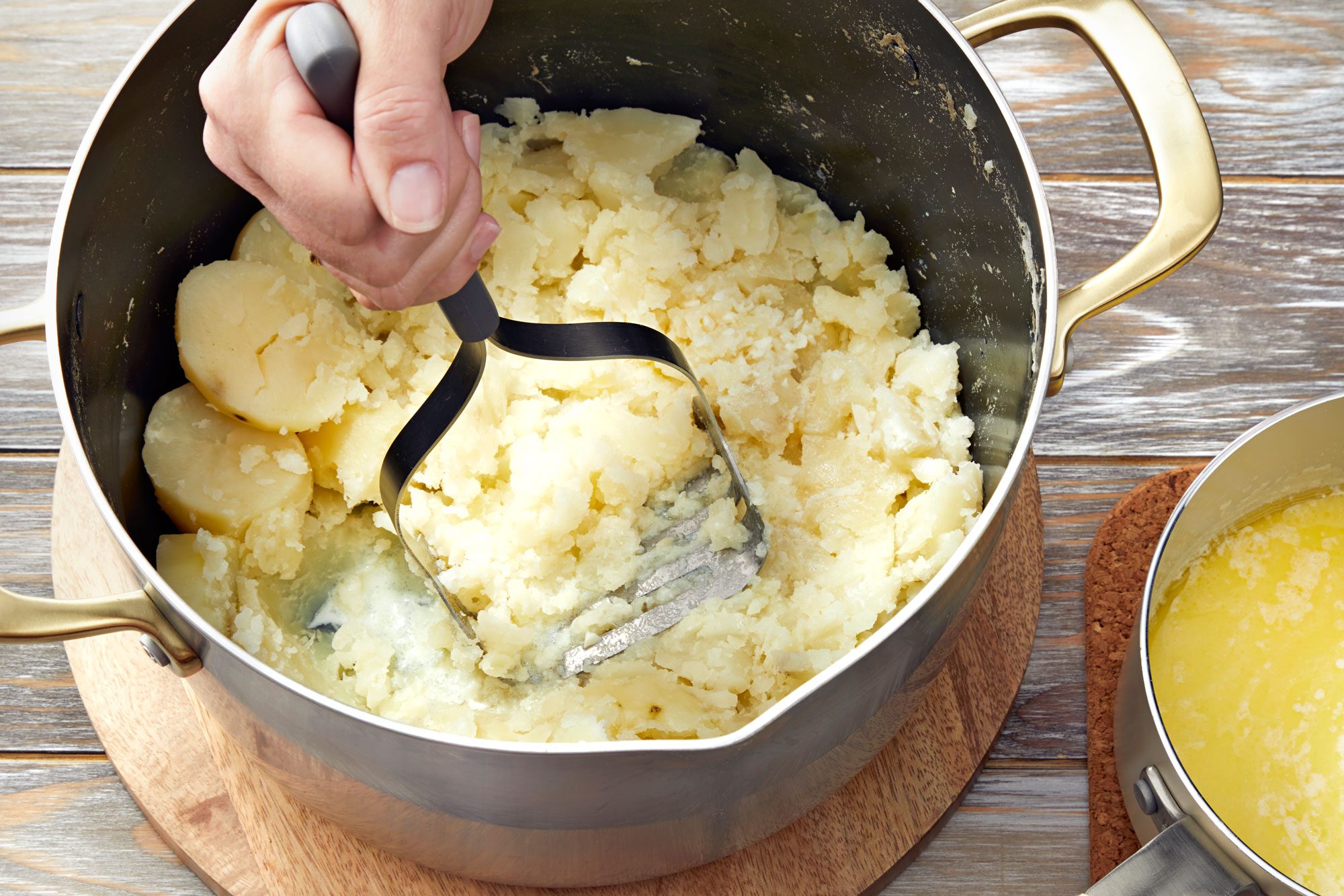 Mash potatoes while gradually adding milk mixture until desired consistency