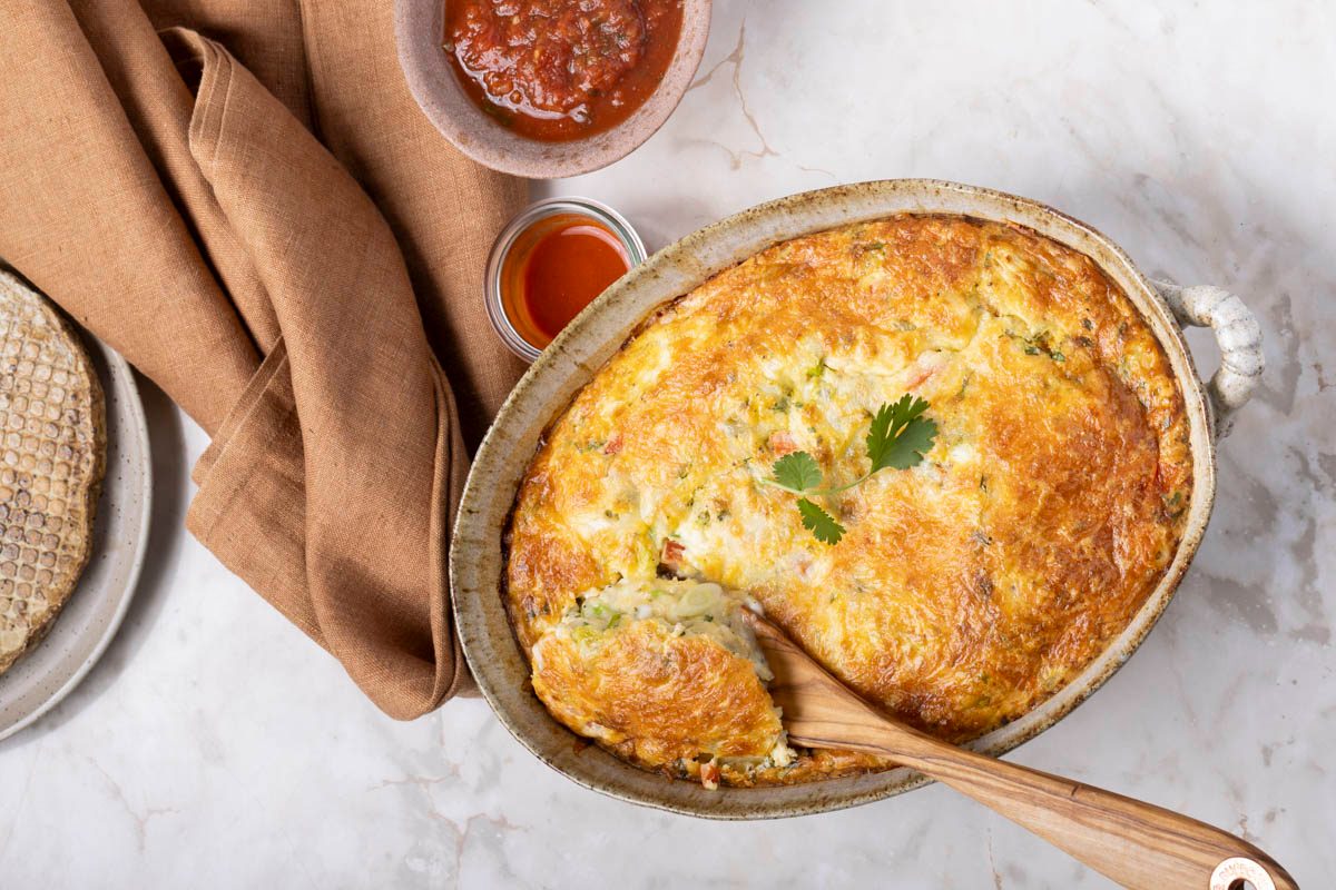 Mexican Breakfast Casserole in a baking dish with wooden spoon on marble table over head