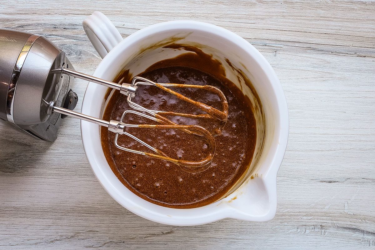 Dry ingredients and hot water are beaten into the molasses mixture for a molasses cake recipe.