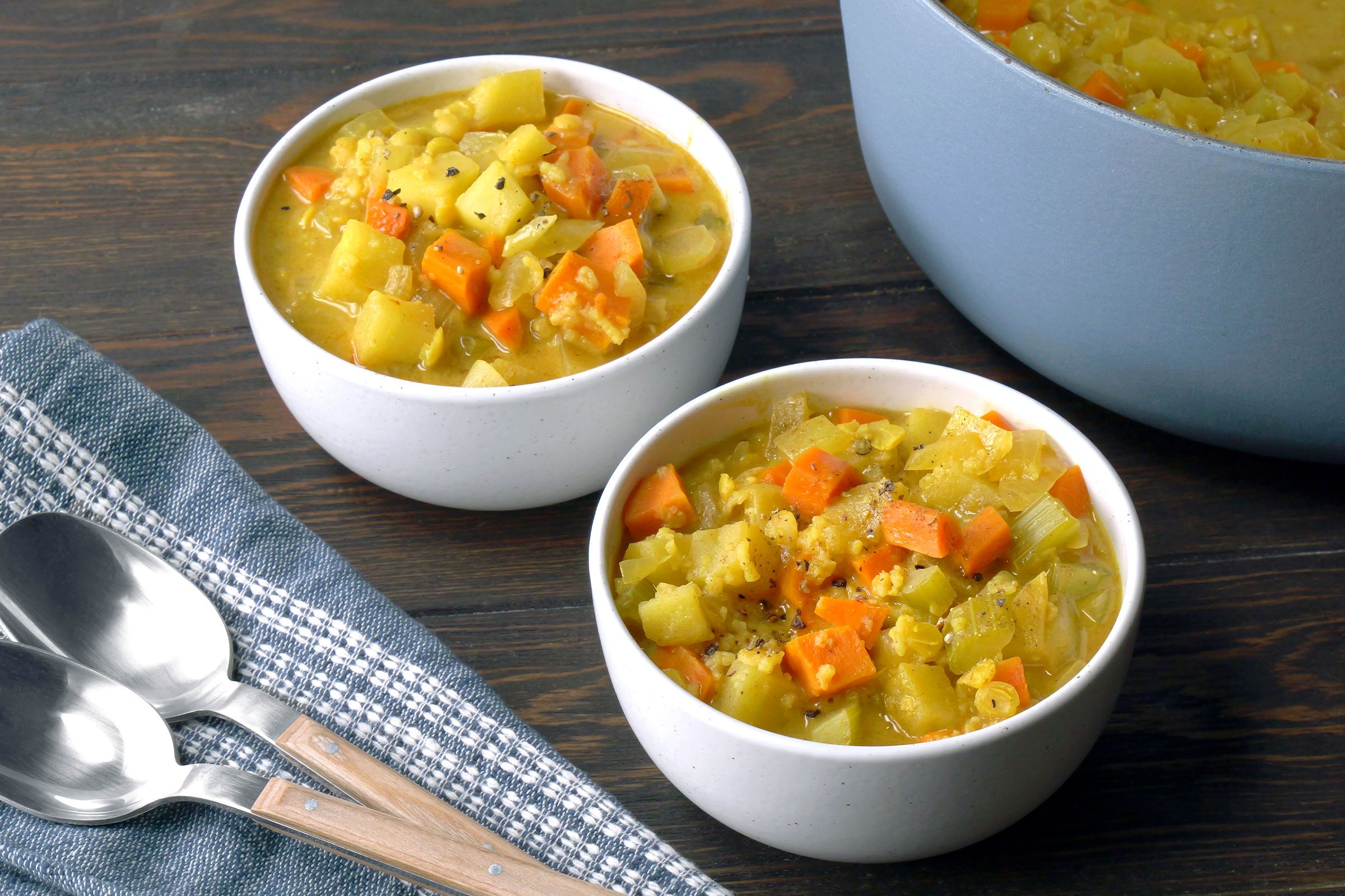 Mulligatawny Soup served in white bowls with spoons on side