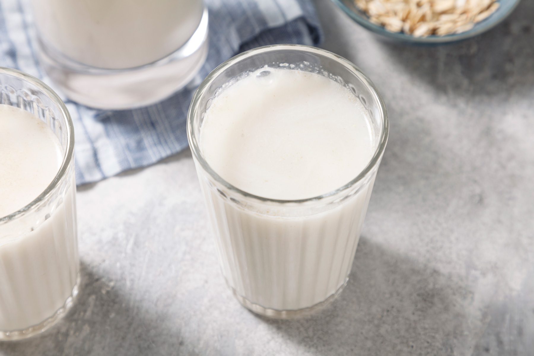 Two glass filled with Oat Milk on a wooden table
