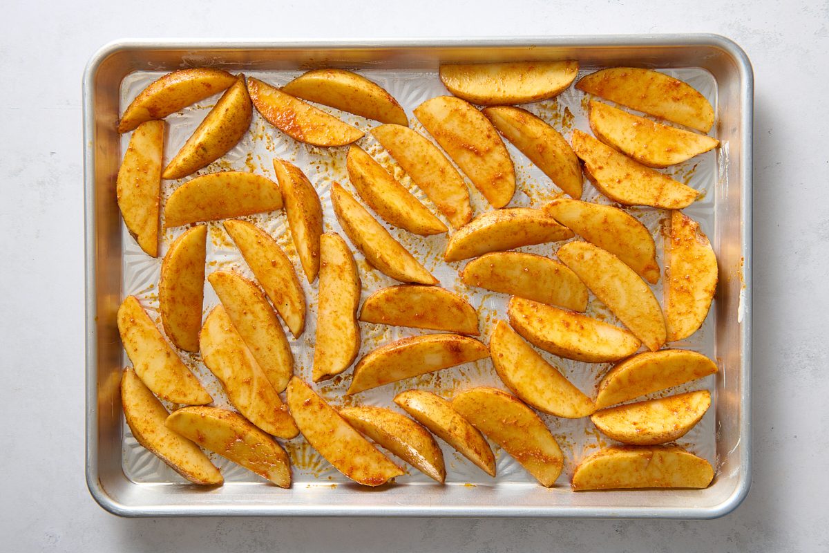 Oven fries spread out on a baking tray