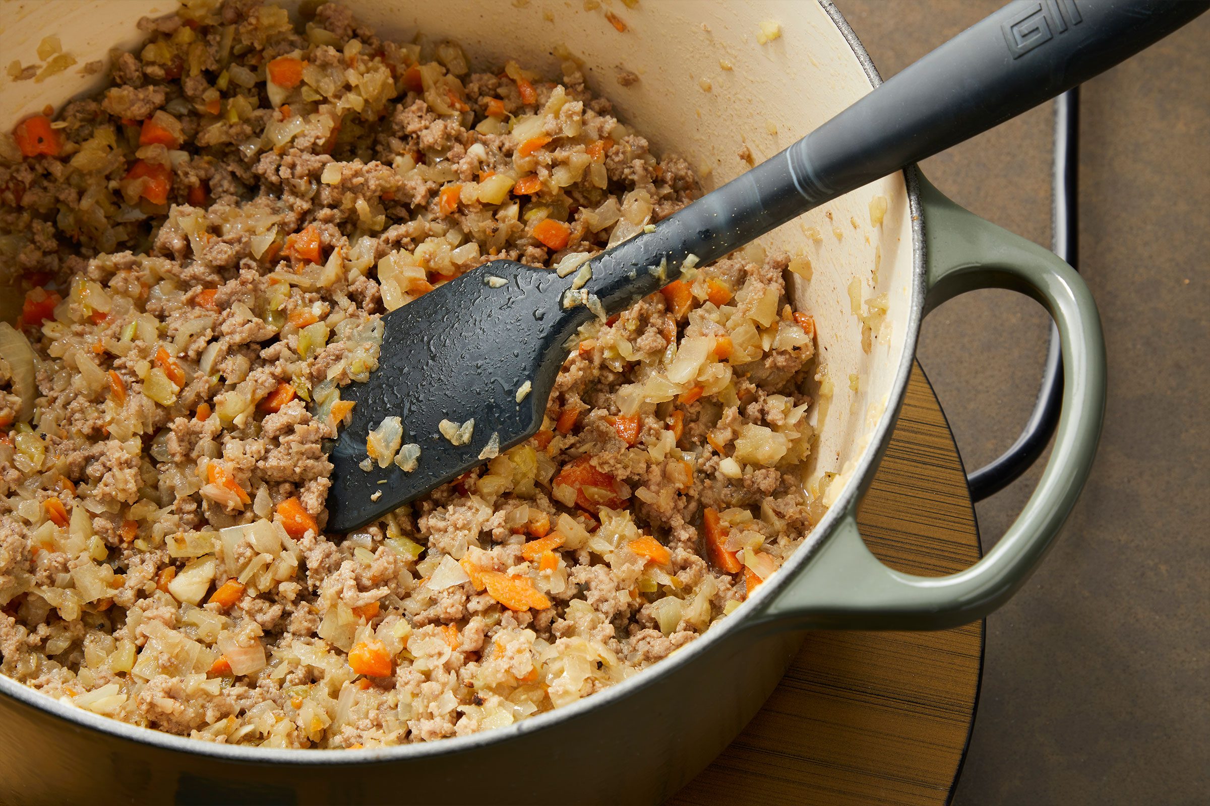Cooking ground beef in a pan with chopped vegetables