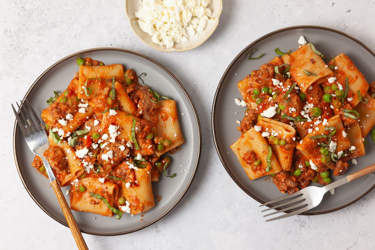 Single Servings Of Taste Of Home Pasta With Sausage and Peas Garnished With Feta And Basil