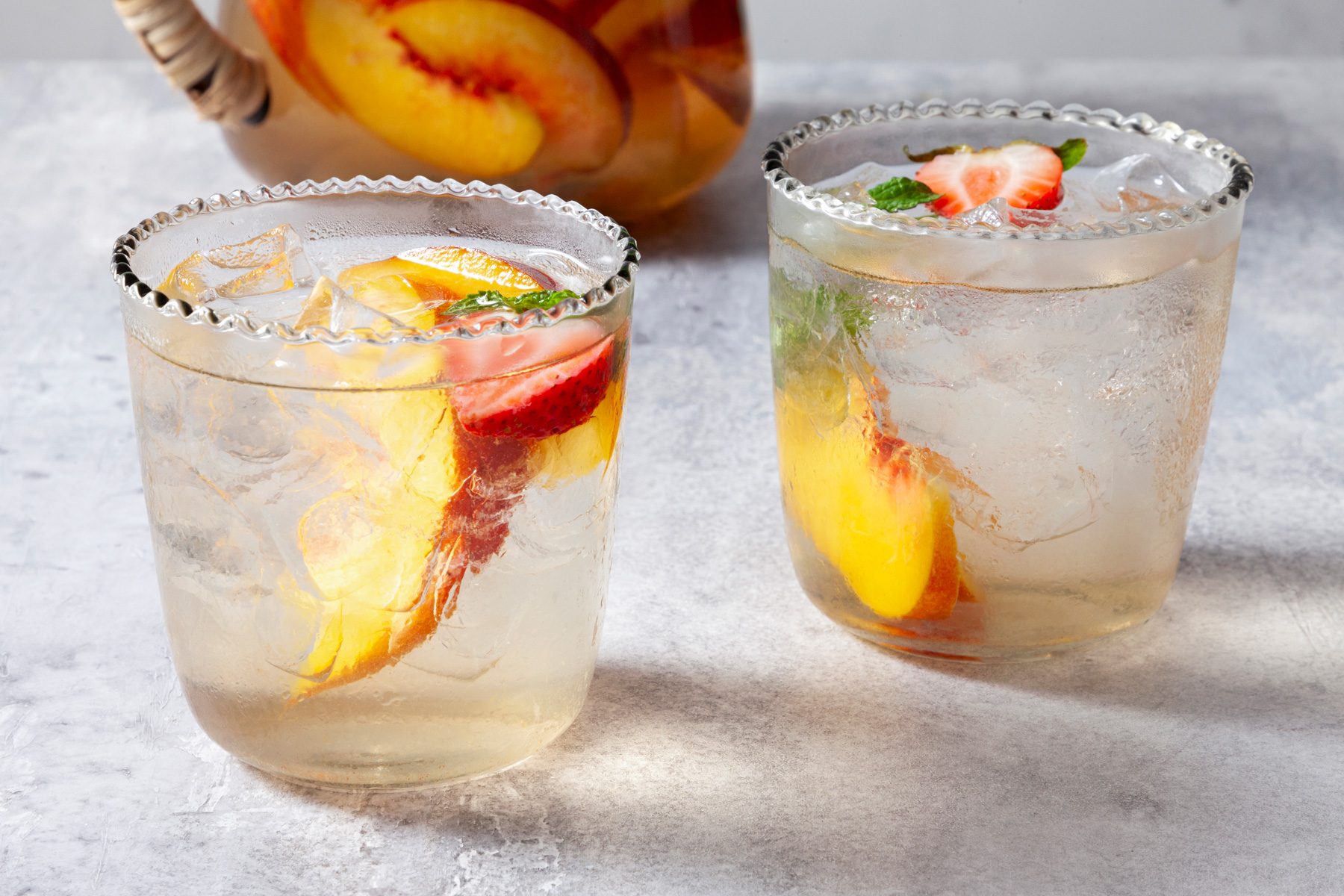 A three-quarter shot features a refreshing glass of easy peach sangria.