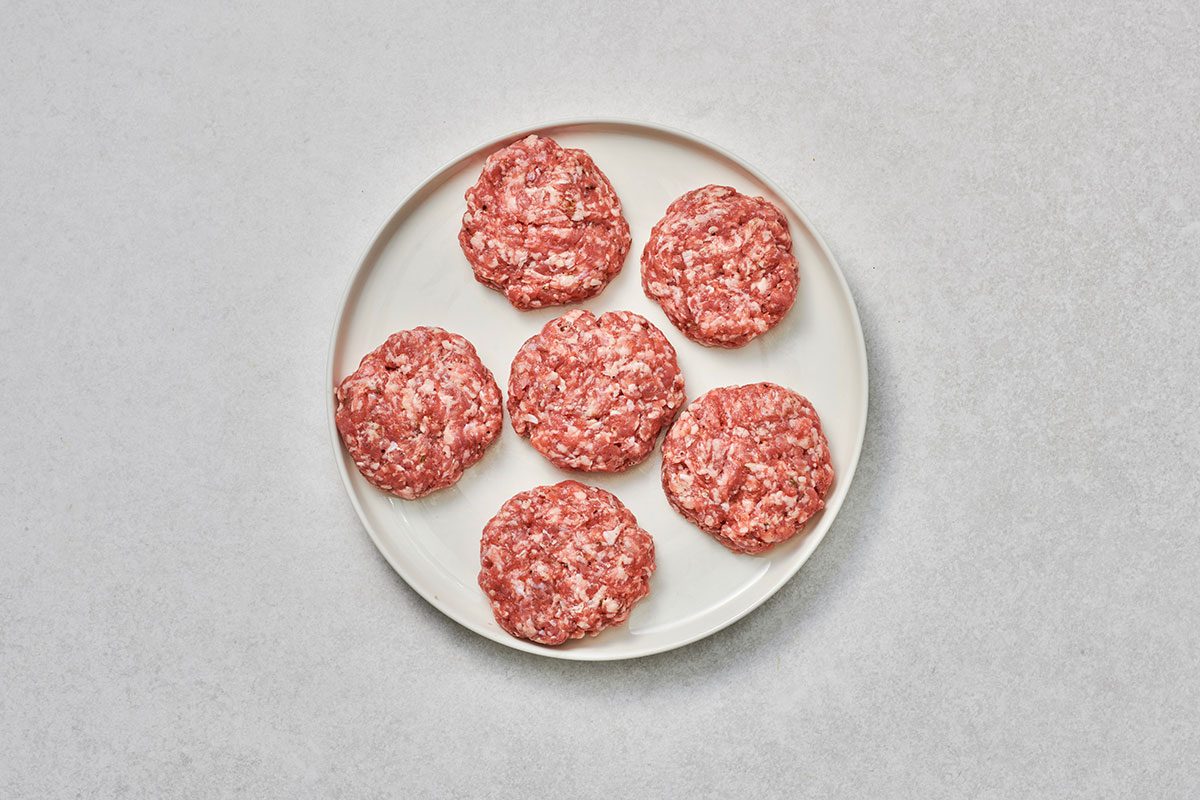 Meat mixture shaped into 6 patties on a plate
