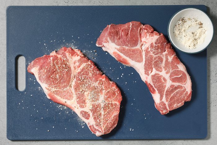 Steaks are sprinkled with salt, pepper, garlic powder, and onion powder.