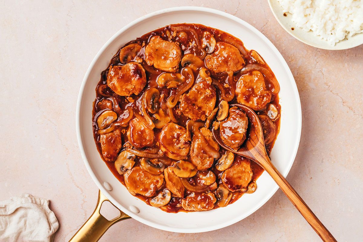 Pork Tenderloin with gravy finished recipe by Taste of Home in a large skillet with a bowl of hot coooked rice as a side