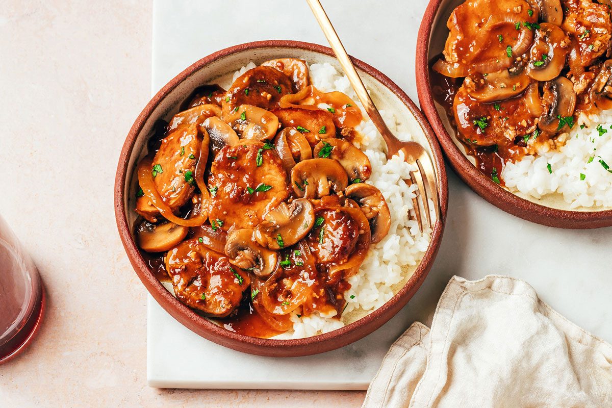 A ceramic plate with hot cooked rice and Pork Tenderloin with Gravy recipe by Taste of Home