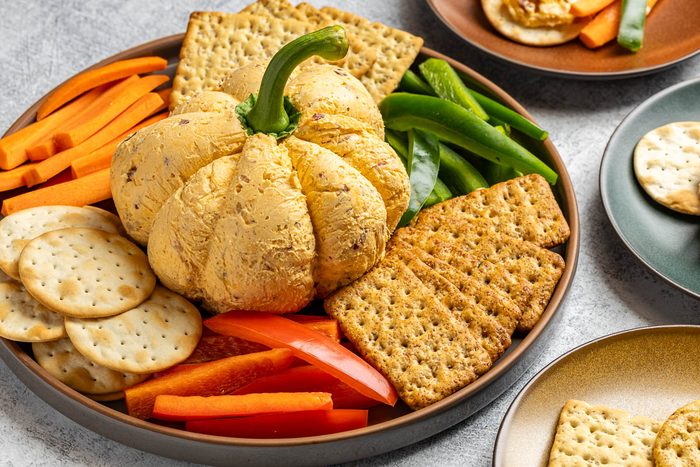 Taste of Home Pumpkin Cheese Ball photo of the finished recipe served with crackers and fresh vegetables.