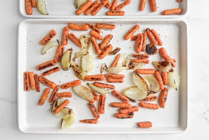 Taste of Home Roasted Carrots and Onions on white baking sheets