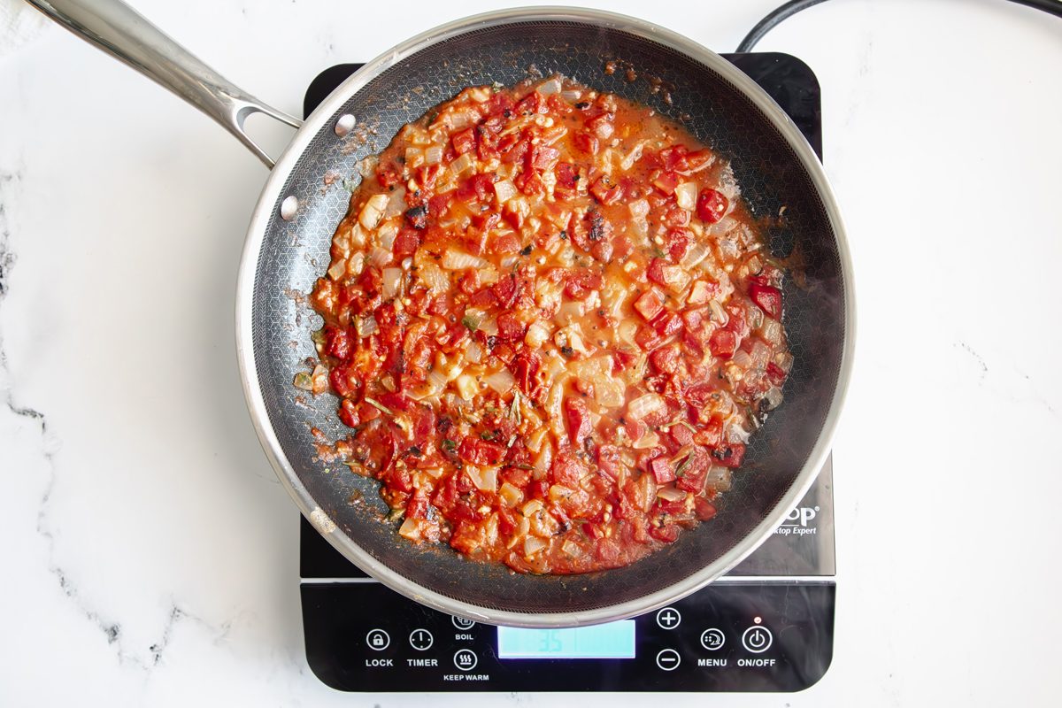 Overhead shot for Taste of Home Seafood Linguine, sauce mixture cooking in a Hexclad over an induction cooktop.
