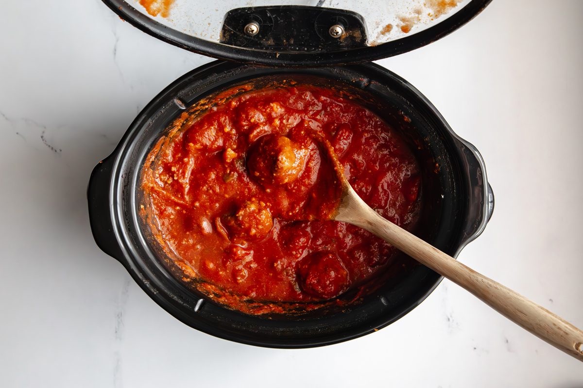 Overhead shot for Taste of Slow-Cooker Spaghetti and Meatballs, meatballs and sauce in a slow cooker after being cooked.