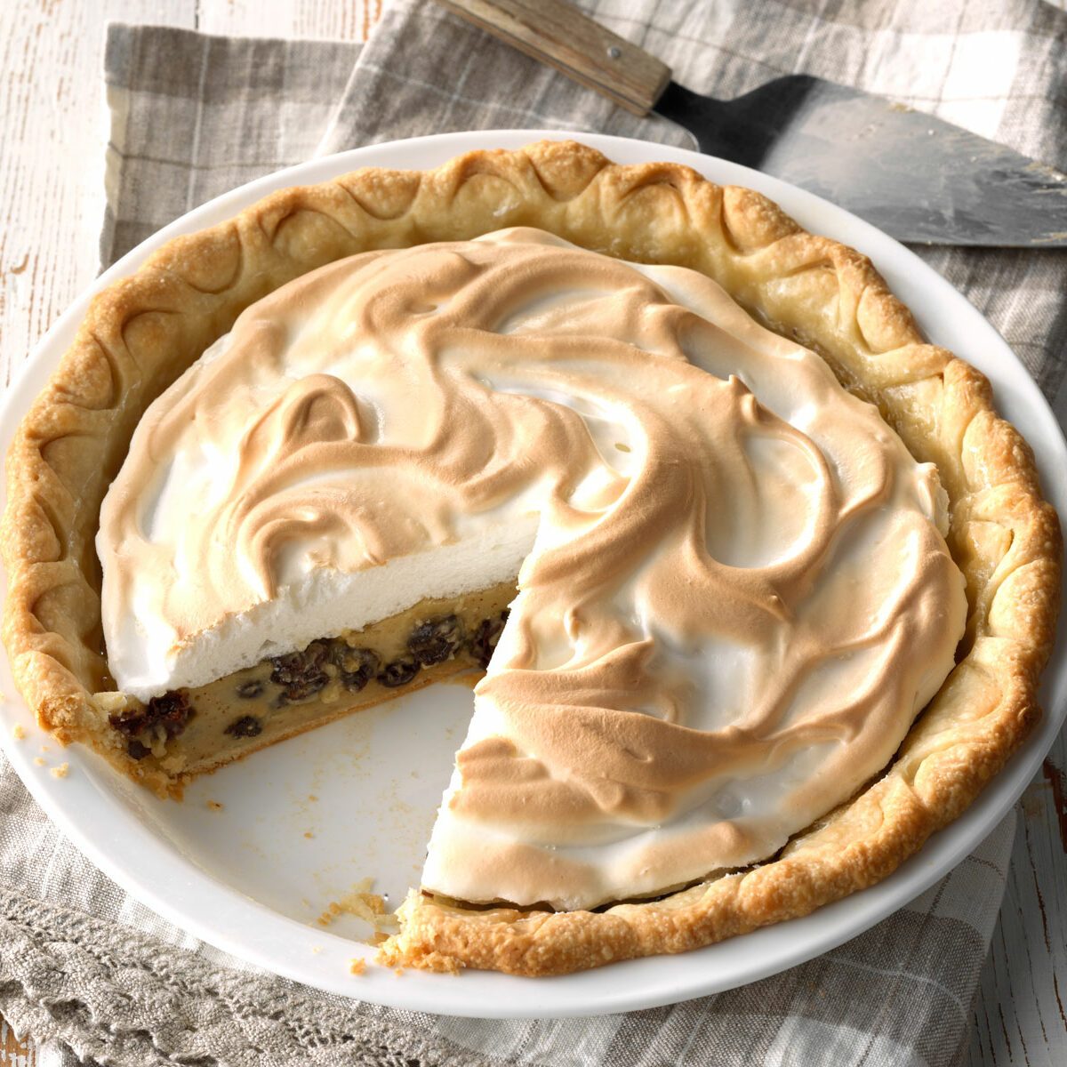 Sour Cream Raisin Pie with a slice taken out of it.