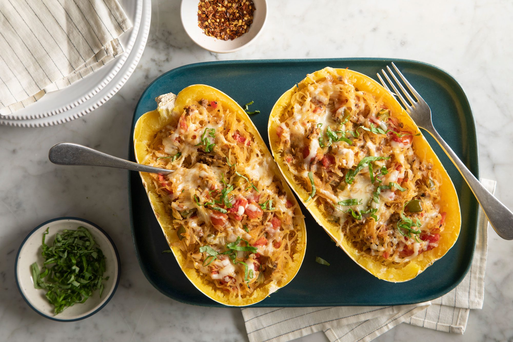 Overhead shot of Spaghetti Squash Boats served on teal blue plate; marble surface;