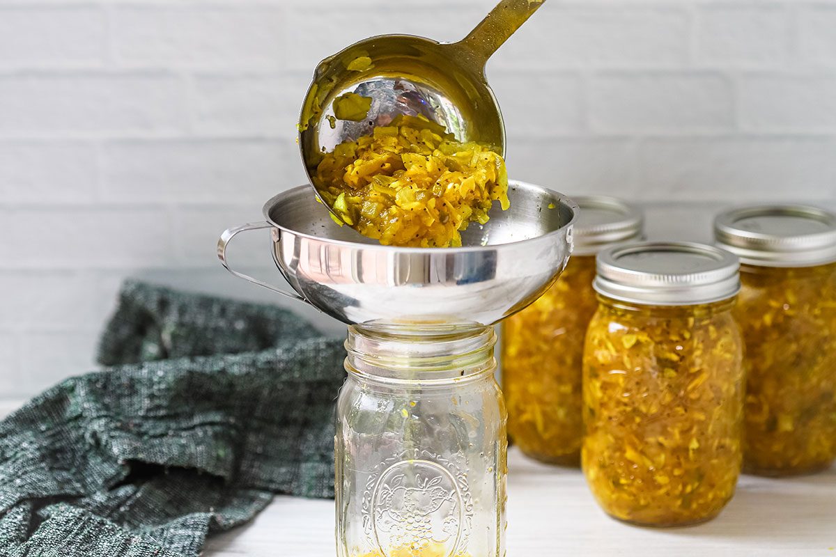 Filling jars with squash relish, a home canning recipe from Taste of Home.