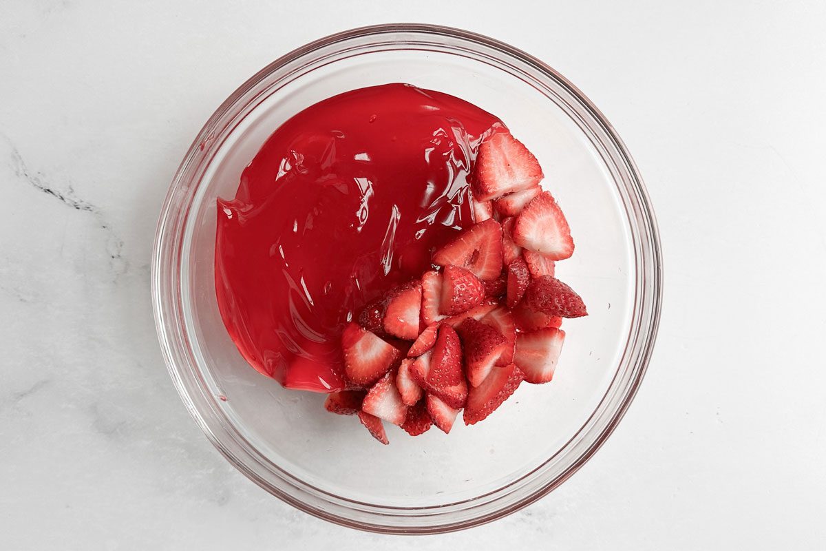Strawberries and strawberry glaze for Taste of Home Strawberry Shortcake Trifle in a glass bowl