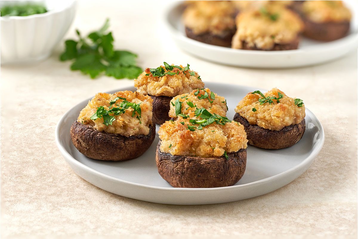 A close-up shot of a Stuffed Mushroom with Crabmeat, highlighting the golden brown topping and creamy filling, by Taste of Home.