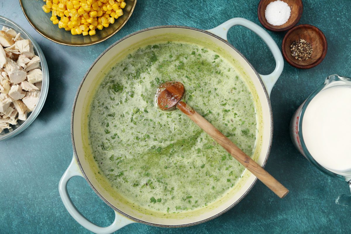 Process of making Taste of Home's Poblano Soup in a large dutch oven on a teal surface.