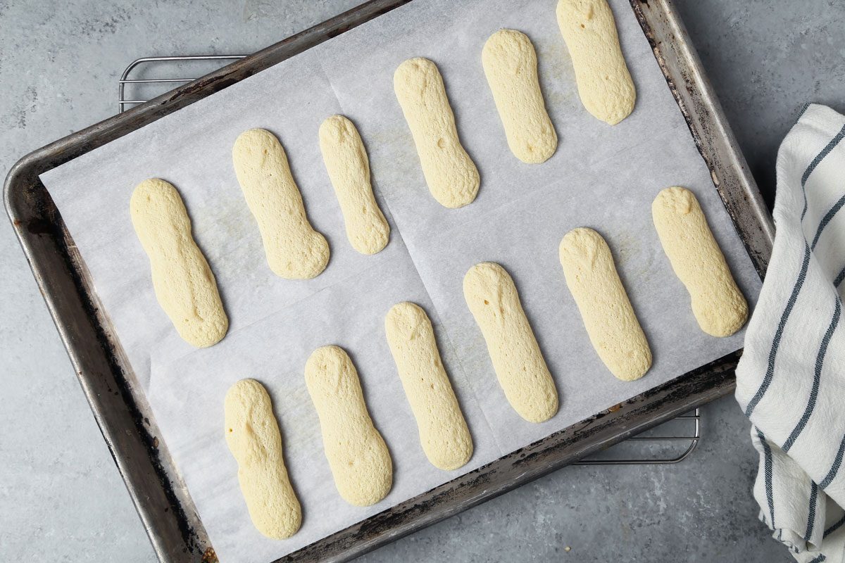 Process of making Taste of Home's Lady Fingers on a baking sheet on a wire rack.