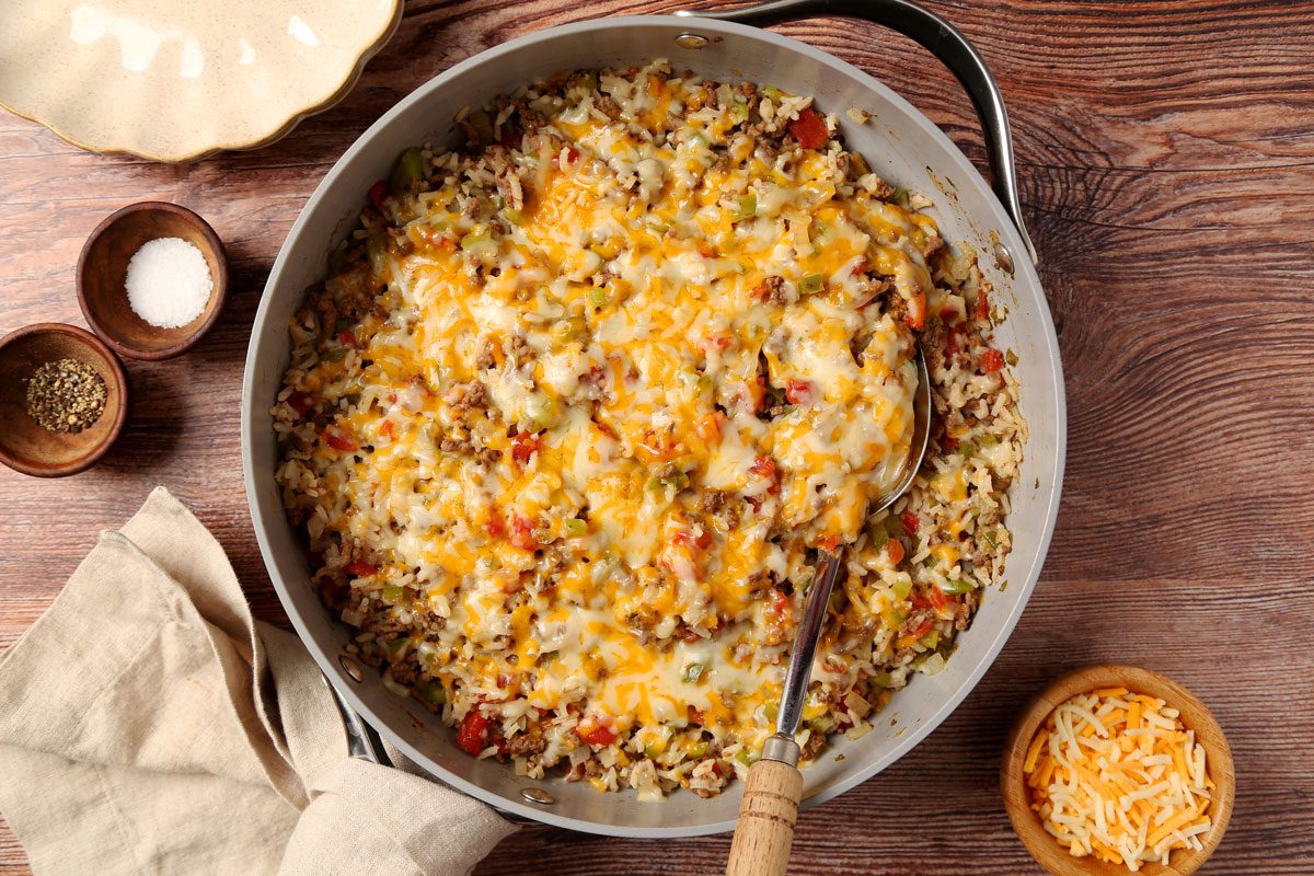 Close up of Taste of Home's Beef and Rice Skillet served on plates on a brown wooden surface.