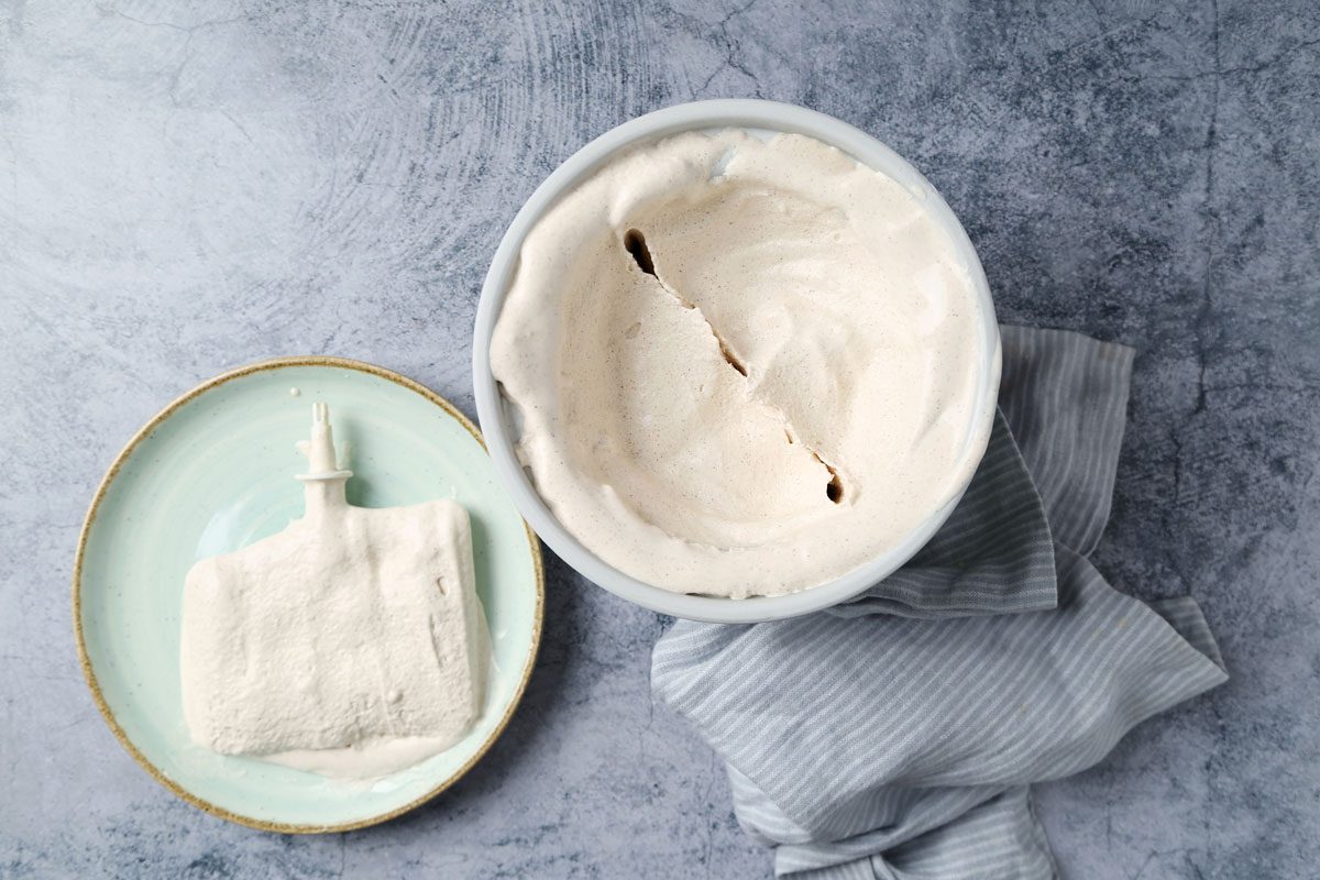 Ingredients for Taste of Home's Cinnamon Ice Cream laid out in small bowls on a blue marble surface.