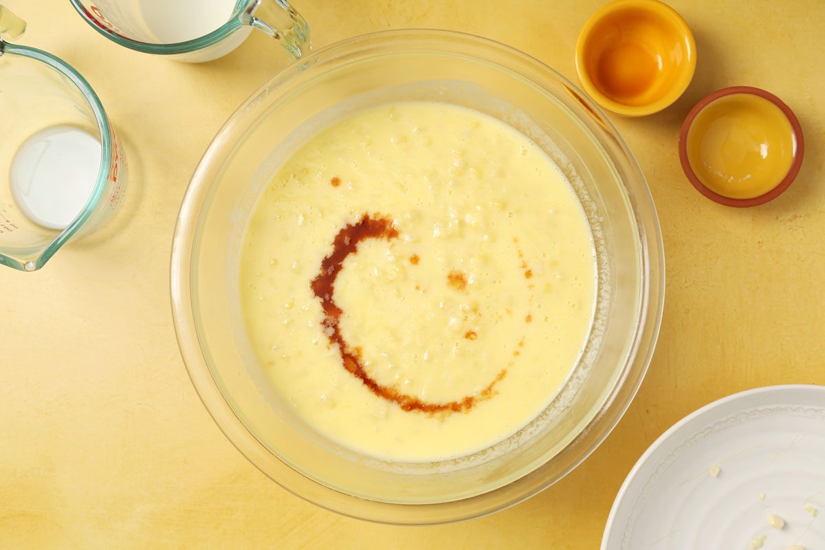 Process of making Taste of Home's Corn Ice Cream making the custard in a large bowl on a yellow surface.