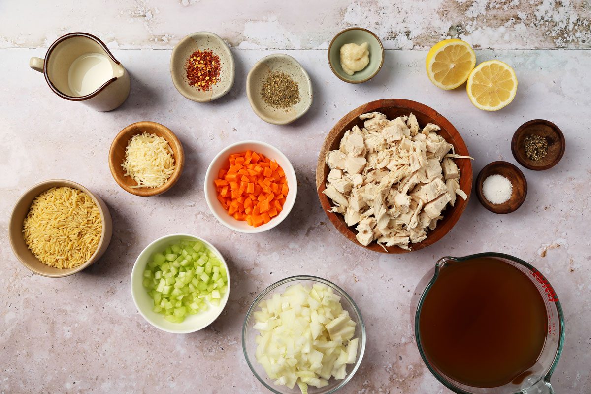 Ingredients for Taste of Home's Chicken Florentine Soup laid out in small bowls on a grey surface.