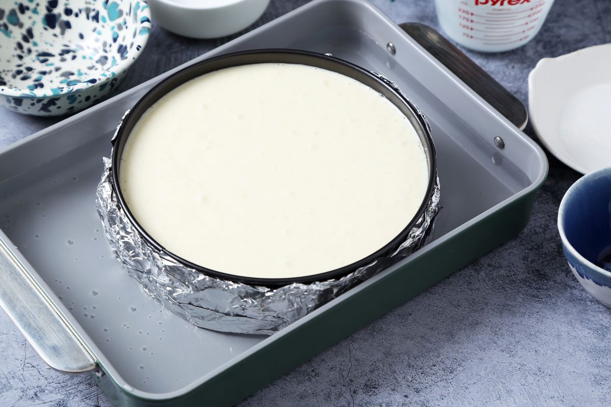 Process of making Taste of Home's Coconut Cheesecake on a dark blue surface.