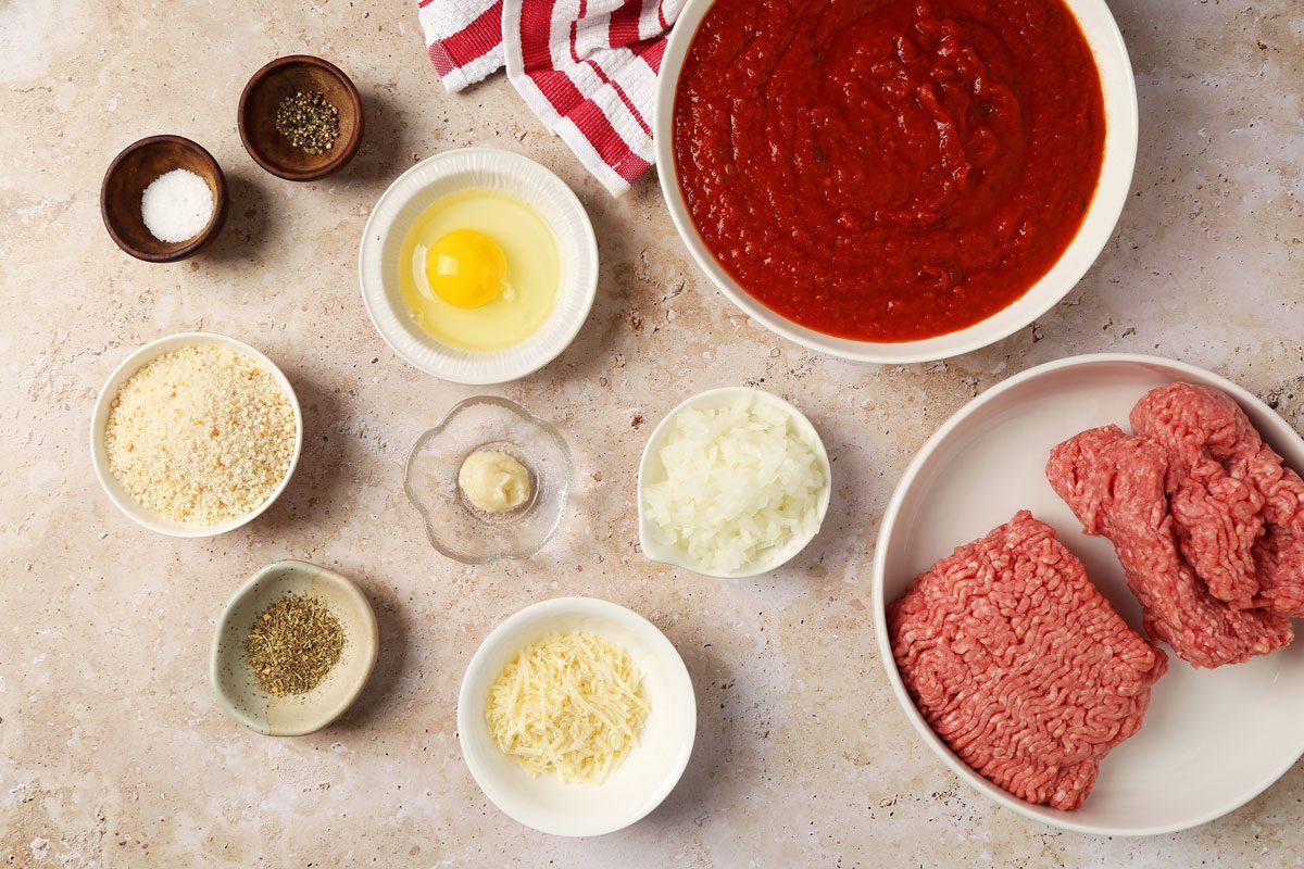 Ingredients for Taste of Home's Instant Pot Meatballs laid out in small bowls on a brown marble surface.