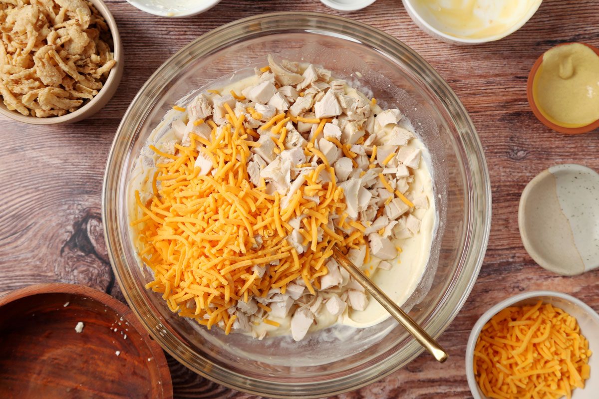Process of making Taste of Home's French Onion Chicken Casserole on a brown wooden surface. Filling in a large mixing bowl.