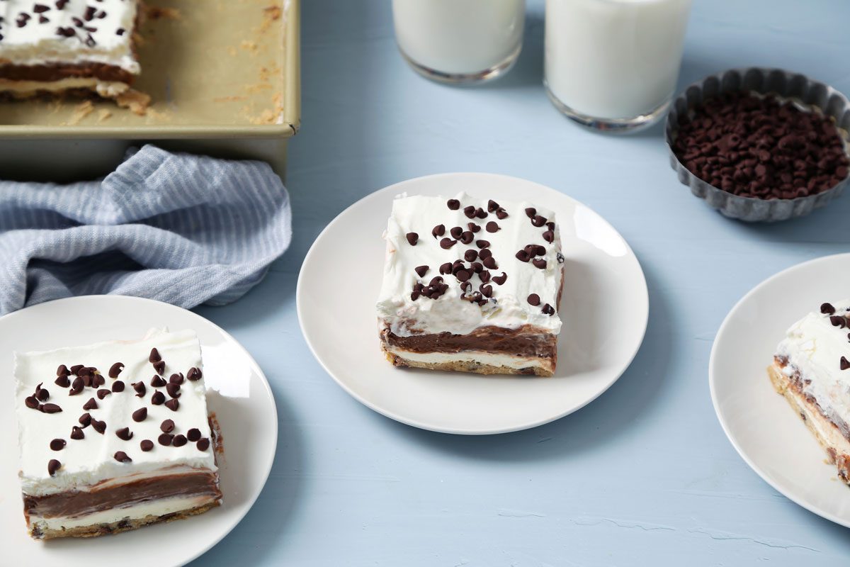Close up of Taste of Home's Chocolate Chip Cookie Delight served on white plates on a light blue surface.