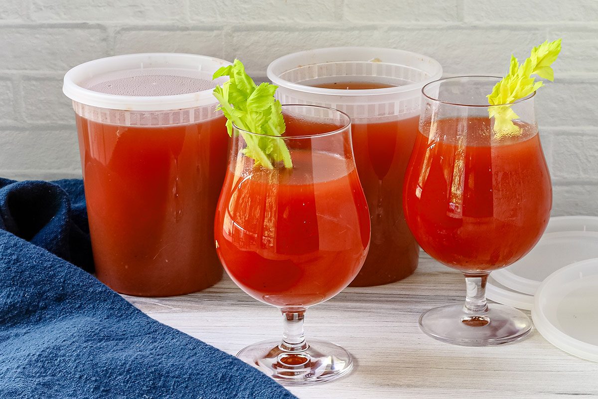 Homemade spicy tomato juice in glasses with celery.