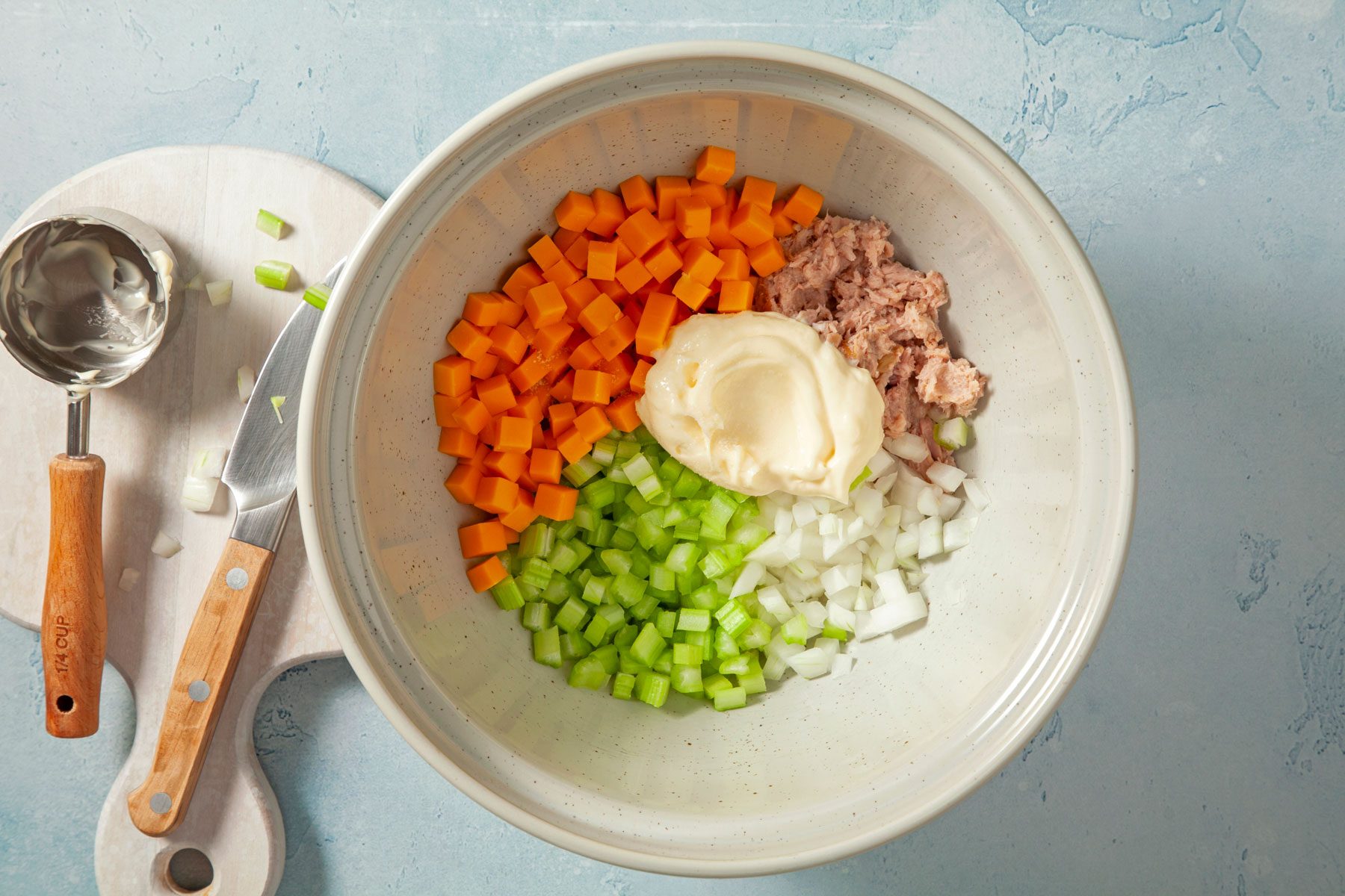 Celery, cheddar cheese, canned tuna, onion, mayo and salt in a bowl.