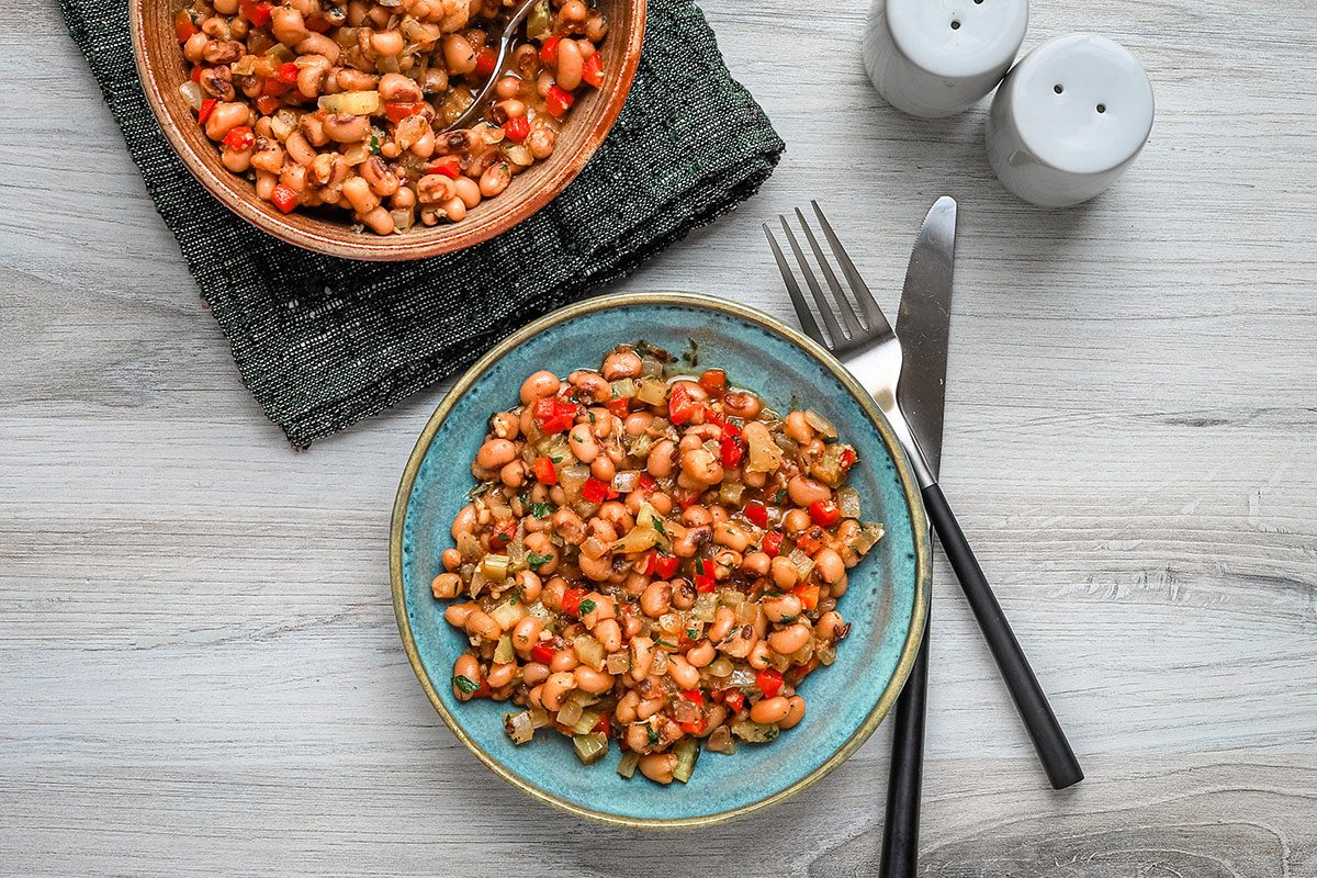 A serving of vegan black-eyed peas with spices, parsley, and aromatic vegetables.