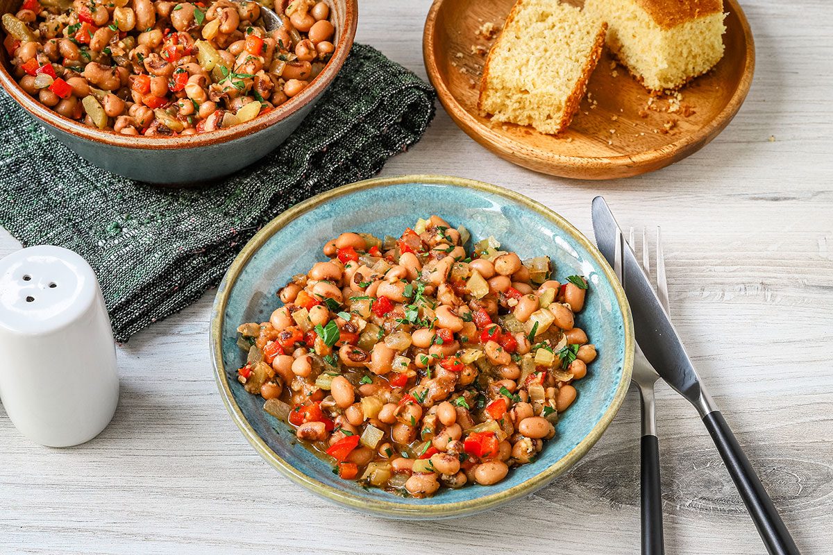 Vegan black-eyed peas and cornbread with a parsley garnish.