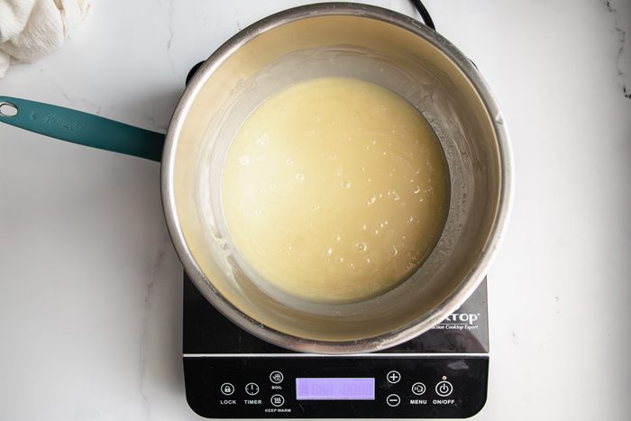 Overhead shot for Taste of Home White Chocolate Ganache, with the white chocolate and heavy cream being melted in a double boiler.