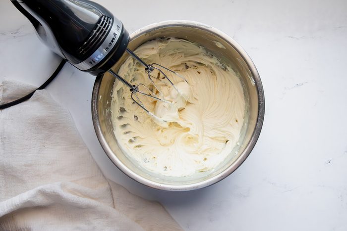Overhead shot for Taste of Home White Chocolate Ganache, white chocolate and heavy cream being whipped together after cooling slightly.