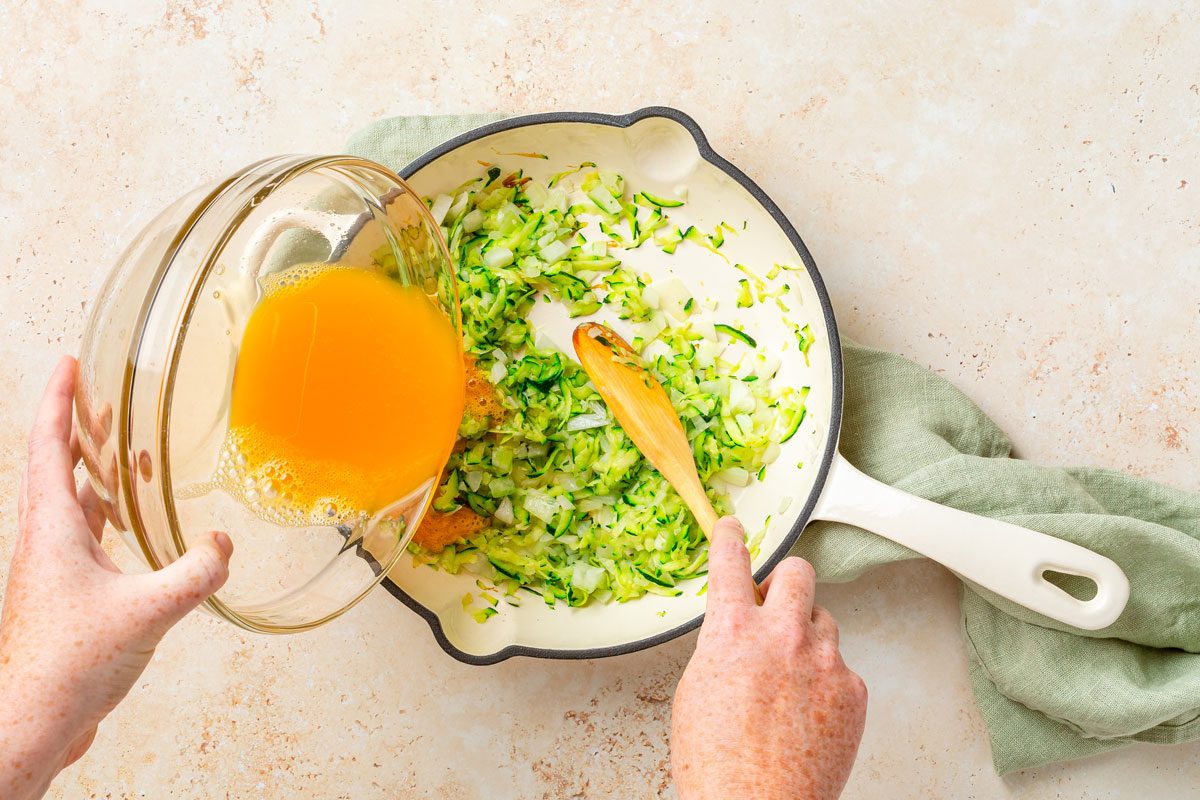 Adding Whisked Eggs In Zucchini And Onion While Frying
